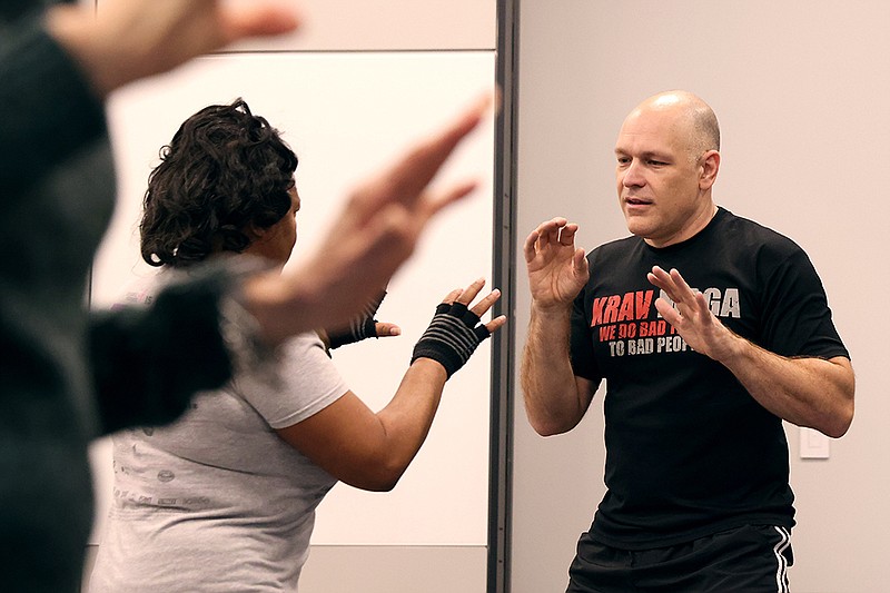 Devin Shirley, right, teaches a Krav Maga self-defense class at the Little Rock-Midtown ArkansasBlue Welcome Center hosted by Arkansas Blue Cross and Blue Shield on Saturday, Dec. 3, 2022. (Arkansas Democrat-Gazette/Colin Murphey)