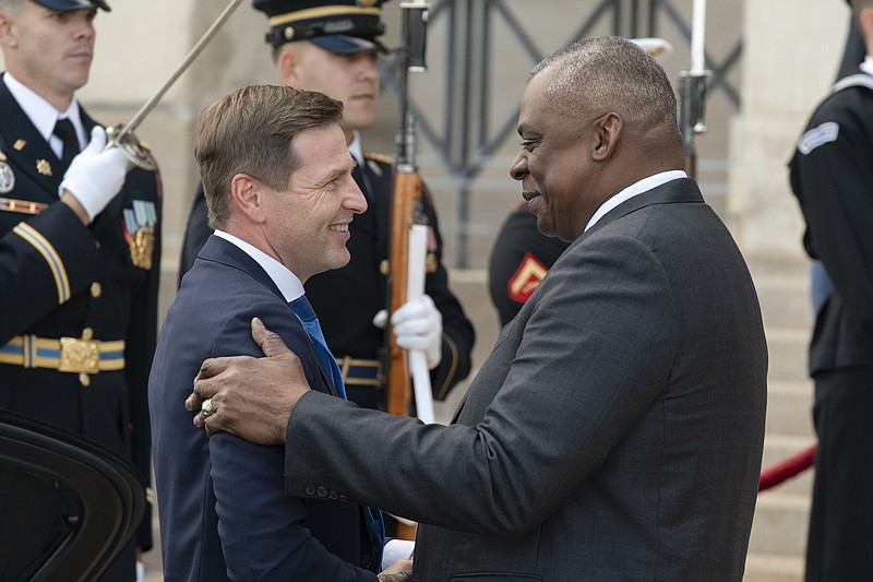 FILE  - Estonia's Defense Minister Hanno Pevkur, left, is greeted by Secretary of Defense Lloyd Austin during an honor cordon ceremony, upon his arrival at the Pentagon, Tuesday, Oct. 18, 2022, in Washington. NATO member and Russia’s neighbor Estonia is boosting its defense capabilities by acquiring an advanced U.S. rocket artillery system. Estonian defense officials said Saturday, Dec. 3, 2022 that the deal with the U.S. worth more than $200 million is the Baltic country’s largest arms procurement project ever. (AP Photo/Alex Brandon, File)