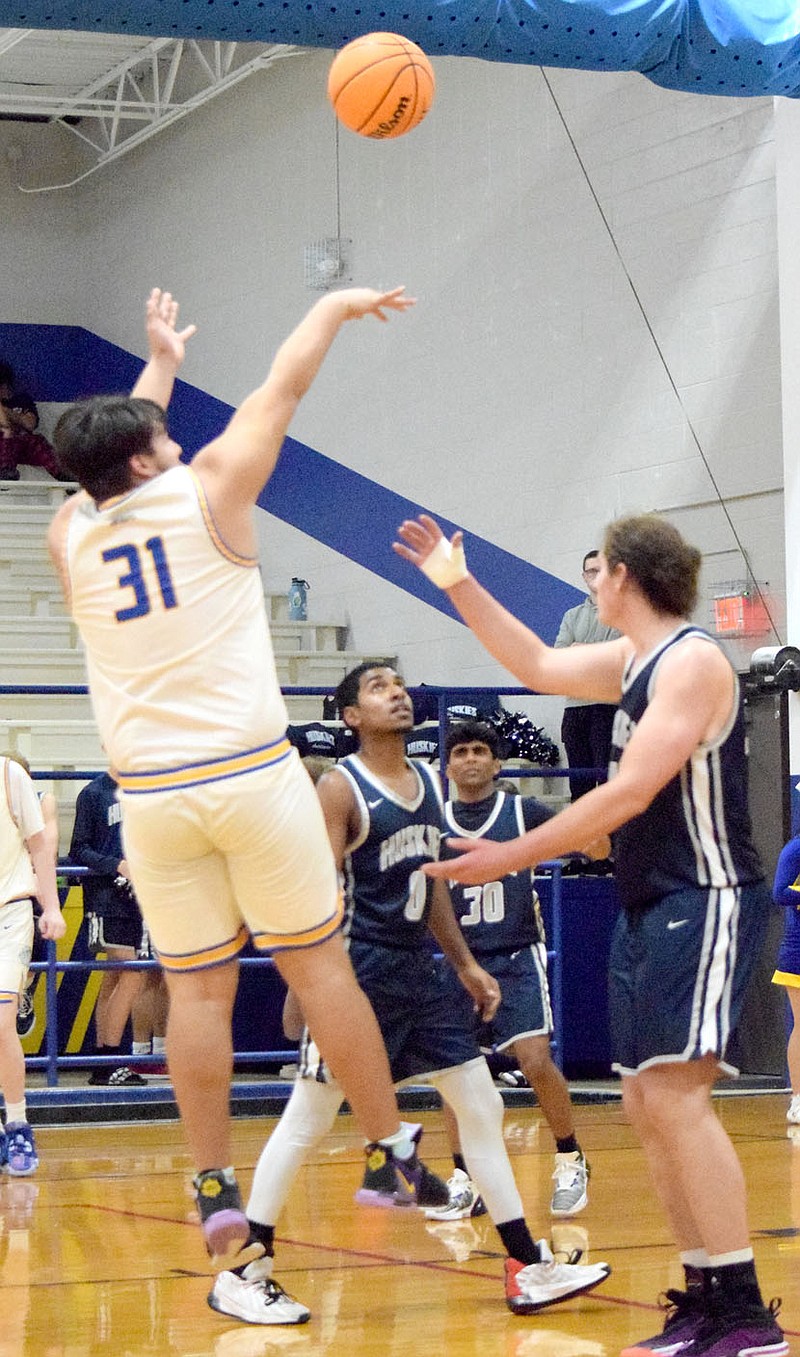 Westside Eagle Observer/MIKE ECKELS Brandon Montano (31) fires a jumper over a pack of Huskies during the fourth quarter of the Decatur-Haas Hall-Bentonville basketball contest in Decatur Nov. 28. The Huskies took the nonconference win, 60-43, over the Bulldogs.