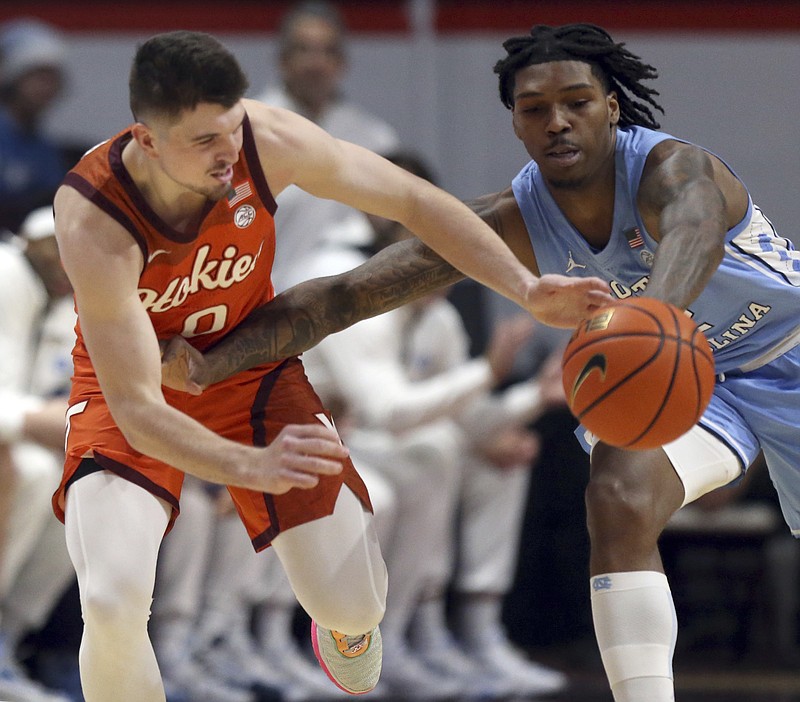 North Carolina's Caleb Love, right, steals a pass intended for Virginia Tech's Hunter Cattoor in the first half of an NCAA college basketball game in Blacksburg Va., Sunday Dec. 4, 2022. (Matt Gentry/The Roanoke Times via AP)