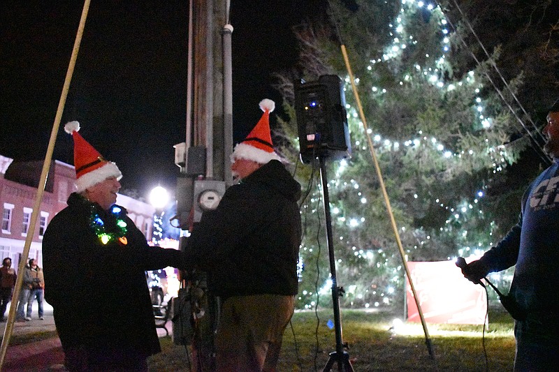 Democrat photo/Garrett Fuller — Bob Staton, left, looks at Ron Harlan on Saturday (Dec. 3, 2022,) after flipping the switch for the Christmas tree lights on the western side of the Moniteau County Courthouse.