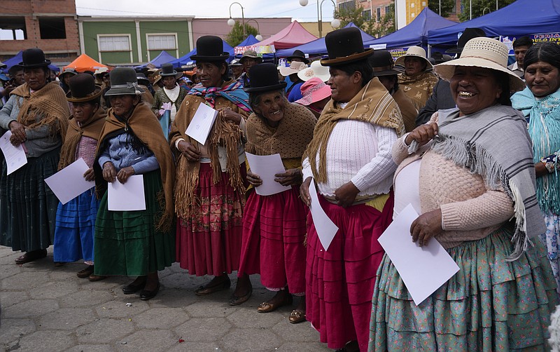 Aymara Indigenous women smile after receiving their certificate during an adult literacy graduation ceremony in Pucarani, Bolivia, Sunday, Dec. 4, 2022. (AP Photo/Juan Karita)