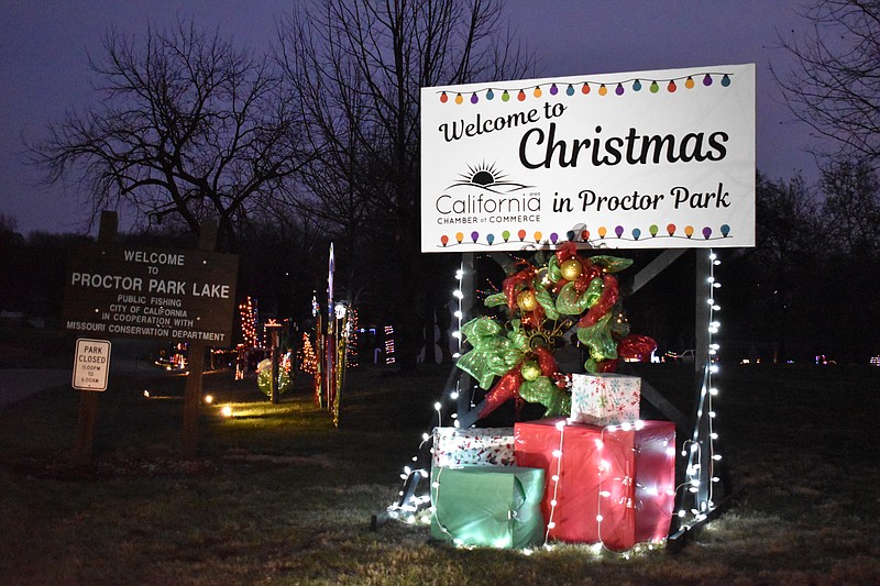 Democrat photo/Garrett Fuller — Stacks of presents, lights and a "Welcome to Christmas in Proctor Park" sign welcome visitors on Monday (Dec. 5, 2022,) to the freshly-lit winter wonderland of Proctor Park.