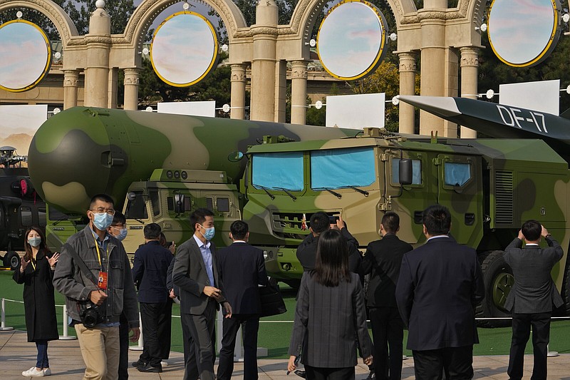 Visitors tour past military vehicles carrying the Dong Feng 41 and DF-17 ballistic missiles at an exhibition highlighting President Xi Jinping and his China's achievements under his leadership, at the Beijing Exhibition Hall in Beijing on Oct. 12, 2022. China strictly adheres to its policy of no first use of nuclear weapons "at any time and under any circumstances," its Defense Ministry said Tuesday, Dec. 6, 2022, in a scathing response to a U.S. report alleging a major buildup in Beijing's nuclear capabilities. (AP Photo/Andy Wong)