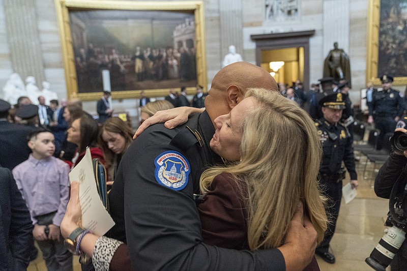U.S. Capitol Police officer Sgt. Harry Dunn, left, hugs Rep. Abigail Spanberger, D-Va., after a Congressional Gold Medal ceremony honoring law enforcement officers who defended the U.S. Capitol on Jan. 6, 2021, in the U.S. Capitol Rotunda in Washington, Tuesday, Dec. 6, 2022. (AP Photo/Alex Brandon)