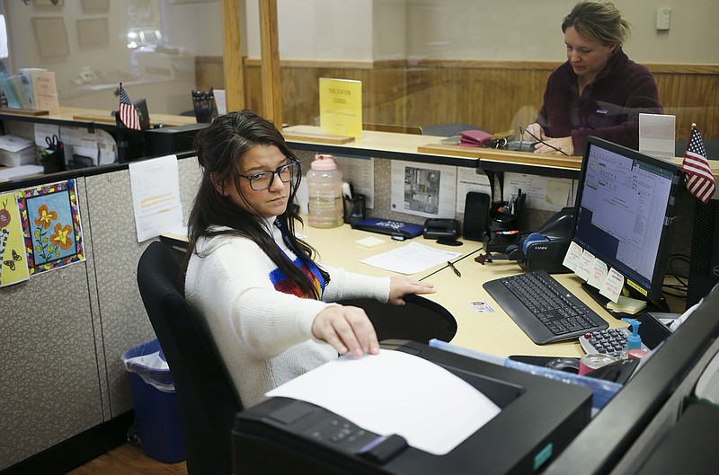Deputy Collector Jessica Yeakley (foreground) helps Tammy Riley of Bentonville on Oct. 20 at the Benton County Collector’s Office in the County Administration Building in Bentonville. 
(File Photo/NWA Democrat-Gazette/Charlie Kaijo)