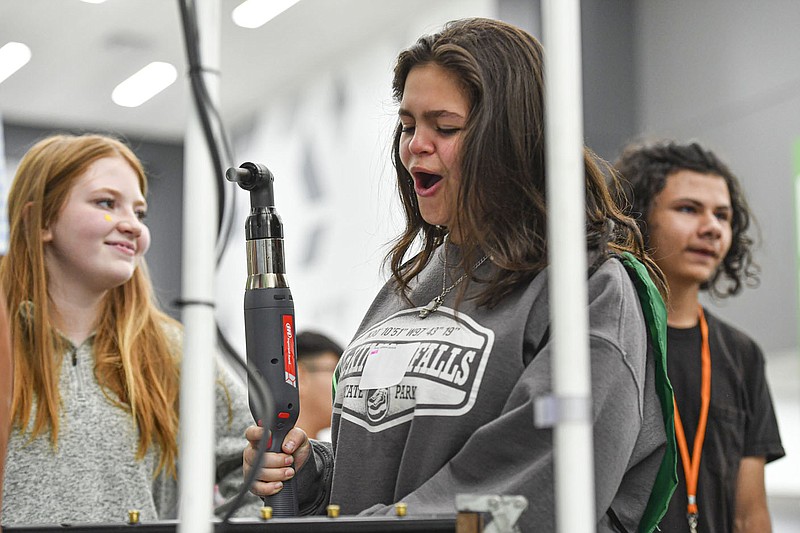 Addison Dorey (center) and Violet Kennigseder (left), eighth-grade students from Chaffin Middle School, react Oct. 18 after Dorey scored a top time in a competition for tightening gas manifold orifices hosted by Rheem at the 2022 iCan Career Expo inside the Peak Innovation Center in Fort Smith.

(File Photo/River Valley Democrat-Gazette/Hank Layton)