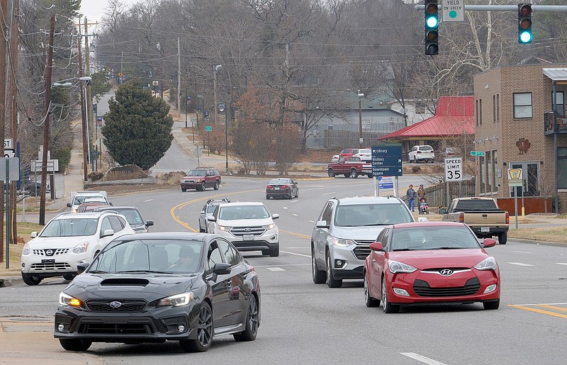 Traffic moves on South School Avenue on Dec. 12, 2018, near the intersection of Martin Luther King Jr. Boulevard in Fayetteville. Regional planners awarded money to several entities this week for projects to reduce or offset pollution from the ever-increasing number of cars and trucks on area roads.
(File Photo/NWA Democrat-Gazette)