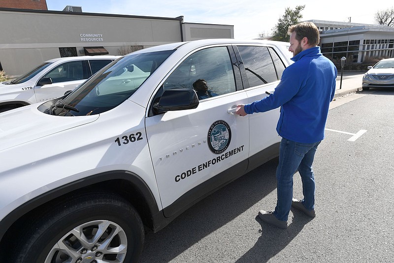 Billy Bryant, senior codes compliance officer with the city of Fayetteville, shows one of the department's vehicles in downtown Fayetteville. Many cities in Northwest Arkansas are grappling with trying to balance proactive enforcement of regulations with a limited amount of staffing, time and money. Visit nwaonline.com/photo for today's photo gallery. 
(NWA Democrat-Gazette/Andy Shupe)