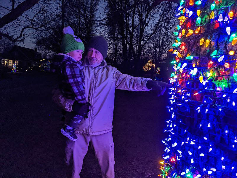 Ryan Pivoney/ News Tribune photo: 
Bob Roling points out to his grandson Luka the Christmas lights wrapping a tree outside 111 Forest Hill Avenue Sunday night, Dec. 11, 2022, at the city's first Porchfestmas.