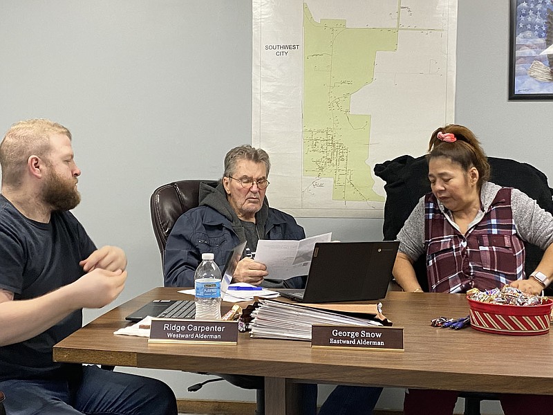 Daniel Bereznicki/MCDONALD COUNTY PRESS Alderman Ridge Carpenter (left), Alderman George Snow, and Alderman Gloria Armstrong, with other council members, review the prices and pictures of the new forks that the public works department is requesting.