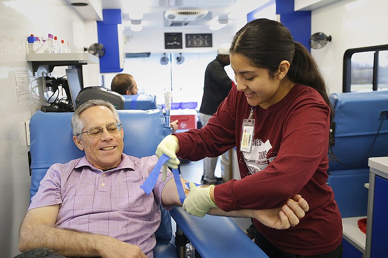 Donor Specialist Alisson Torres (right) draws blood from Paul David of Centerton (left), Monday, December 12, 2022 during a mobile blood drive at the parking lot of the Life Way Christian School in Centerton. Community Blood Center of the Ozarks aimed to collect 20 units of blood. ‘We’re still trying to supply all the hospitals we supply,’ said Collection Supervisor Tasha Alvey. The blood center provides blood to over 40 hospitals in Northwest Arkansas, Southwest Missouri and the southeast corner of Kansas. They will have another blood drive tomorrow at the Ozarks Community Hospital in Gravette from 9am to 3pm and on Wednesday at the Highlands United Methodist Church in Bella Vista from 10am to 3pm. Visit nwaonline.com/photo for today's photo gallery.

(NWA Democrat-Gazette/Charlie Kaijo)