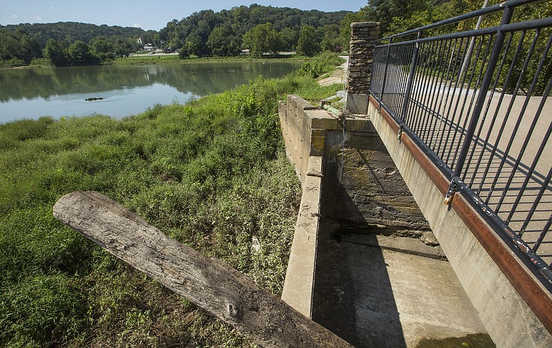 A log protrudes from one of the spillways in the Lake Bella Vista dam on Sept. 4, 2019, at Lake Bella Vista in Bentonville. (File Photo/NWA Democrat-Gazette)