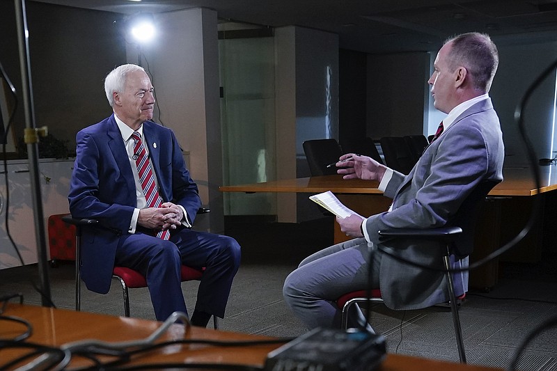 Arkansas Governor Asa Hutchinson, left, during an interview with Andrew DeMillo, right, of the Associated Press, Tuesday, Dec. 13, 2022 in Washington. (AP Photo/Pablo Martinez Monsivais)