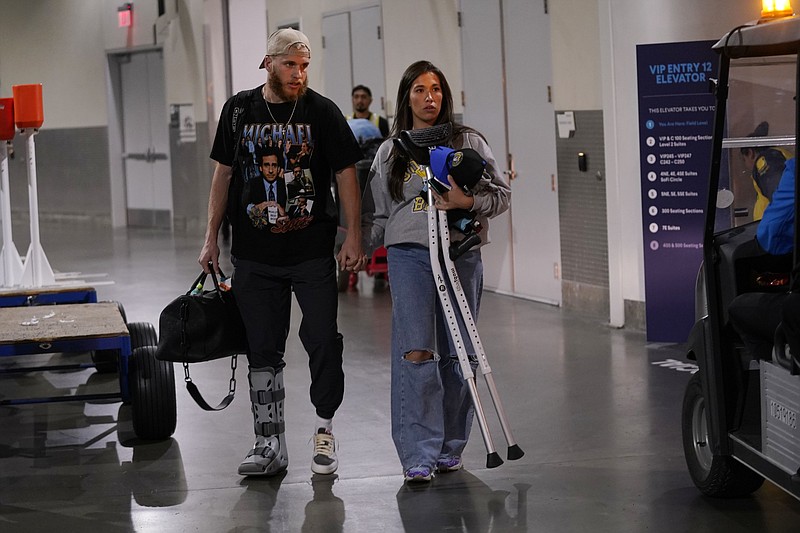 Los Angeles Rams wide receiver Cooper Kupp, left, walks out in street clothes and a boot on his foot with wife Anna after Kupp suffered an injury in an NFL football game against the Arizona Cardinals Sunday, Nov. 13, 2022, in Inglewood, Calif. (AP Photo/Mark J. Terrill)
