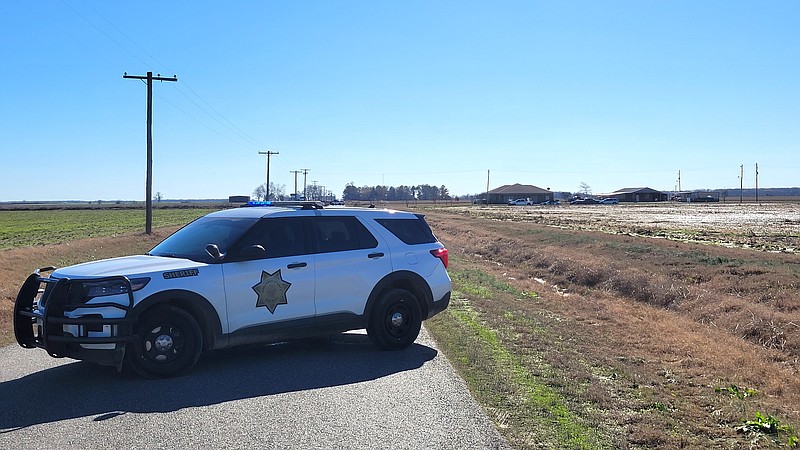 An Arkansas County Sheriff's unit blocks Yoder Road Thursday just south of Stuttgart and north of the home where a man, who was believed to have killed a Stuttgart police officer, was killed in a shootout with state police. (Pine Bluff Commercial/I.C. Murrell)