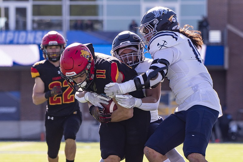 Ferris State wide receiver Dezmin Lyburtus (11) is tackled by Colorado School of Mines safety Jaden Williams (32) and linebacker Adrian Moreno (15) in the first half of the NCAA Division II college football championship on Saturday, Dec. 17, 2022 in McKinney, Texas. (AP Photo/Emil T. Lippe)