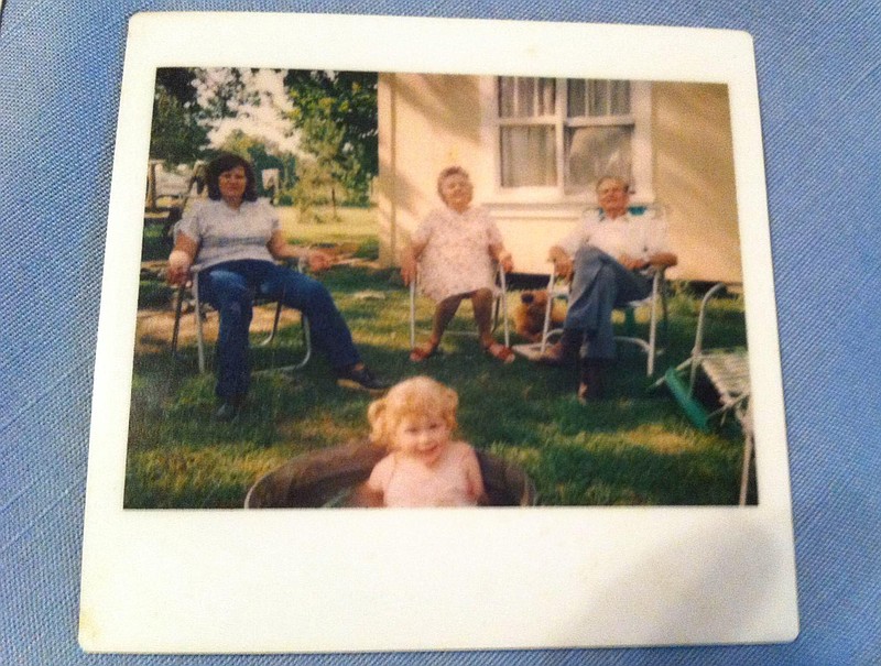 I don't have a picture of the pine tree, but I do have a picture of myself playing in a washtub while my mom, grandmother and grandfather sit under its shade on a warm day. If you squint, you can see the sandpile in the background.