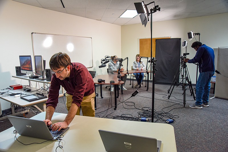 Julie Smith/News Tribune photo:
John Fandrey sets up laptops while in the digital lab in the lower level of Page Library Monday, Dec. 19, 2022. Fandrey is chief information officer at Lincoln University and is gearing up for grant money the university will utilize for equipment like laptops, hot spots and more. The university has a room outfitted with other technology that is available for students to be able to create a podcast and/or video podcast. In the background is recent graduate Julian Jackson-Linkhart and Stacy Winters, media assistant and at right behind the camera is Leangelo Bradley, assistant librarian.