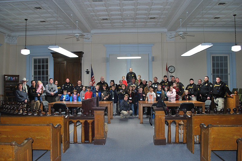 Submitted — Shop with a Cop participants pose Thursday night in the Moniteau County Courthouse with law enforcement officers prior to the trip to Target in Jefferson City. Moniteau County Sheriff Tony Wheatley said 25 children participated in the event, with ages ranging from 3 to 14 years old.