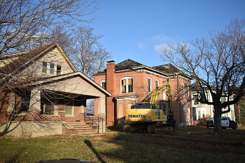 Democrat photo/Garrett Fuller — Two dilapidated homes await their fate Dec. 9 as demolition crews move equipment on the property at 209 S. Oak St.