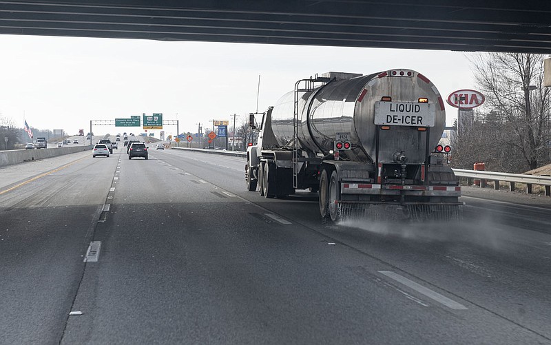 An Arkansas highway department truck spreads Liquid de-icer on I-49 in Wednesday in Bentonville.  (NWA Democrat-Gazette/Spencer Tirey)