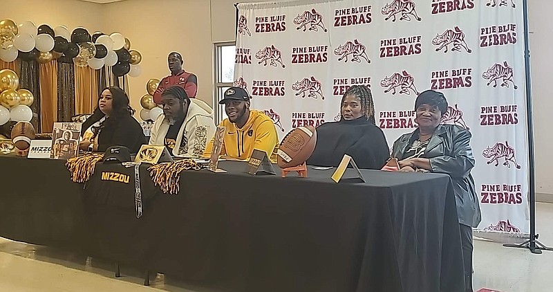 Pine Bluff High Zebra senior Jordon Harris smiles with his family Wednesday as he prepares to sign a national letter of intent to play football for the University of Missouri Tigers. (Pine Bluff Commercial/Suzi Parker)