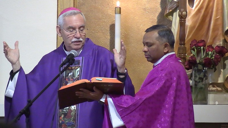 Bishop Anthony B. Taylor dedicates the new statue at St. Mary of the Springs Catholic Church while the Rev. Ravi Gudipalli, pastor of the church, holds the Roman Missal. - Photo by Lance Porter of The Sentinel-Record