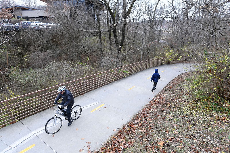 A cyclist and a walker make their way Dec. 14 along the Razorback Greenway in Fayetteville. Visit nwaonline.com/photo for today’s photo gallery. (NWA Democrat-Gazette/Andy Shupe)