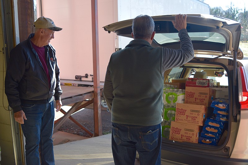Gary Nugent, left, and Bob Clements look over a load of food products they loaded at Project HOPE Food Bank recently. - Photo by Donald Cross of The Sentinel-Record
