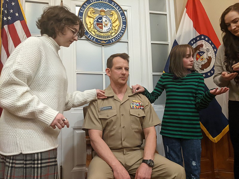 Ryan Pivoney/News Tribune photo: 
U.S. Navy Capt. Alan Mengwasser gets pinned by his daughters, Eliza (left) and Petra (right), during a ceremony Monday, Dec. 26, 2022, in Lt. Gov. Mike Kehoe's Office at the Missouri Capitol. Monday was the first time Mengwasser, 48, participated in a commissioning ceremony surrounded by hometown friends and family.