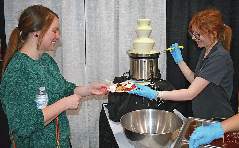 Gerry Tritz/News Tribune file photo: 
At right, Emma Hees of Sweet Chipotle Catering hands a plate of food to Jade Moeller during the 35th annual Bridal Spectacular at The Linc.