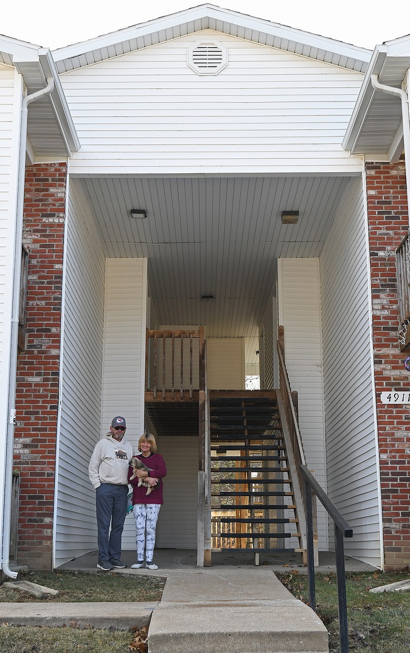 Eileen Wisniowicz/News Tribune photo: 
Arthur and Margaret Peters pose for a photo while holding their dog Oakley on Friday, Dec. 30, 2022 in front of their apartment at Cedar Ridge Apartments. The Peters have lived in the apartment complex since July and said they've enjoyed it. "Good neighbors, good management," commented Margaret.