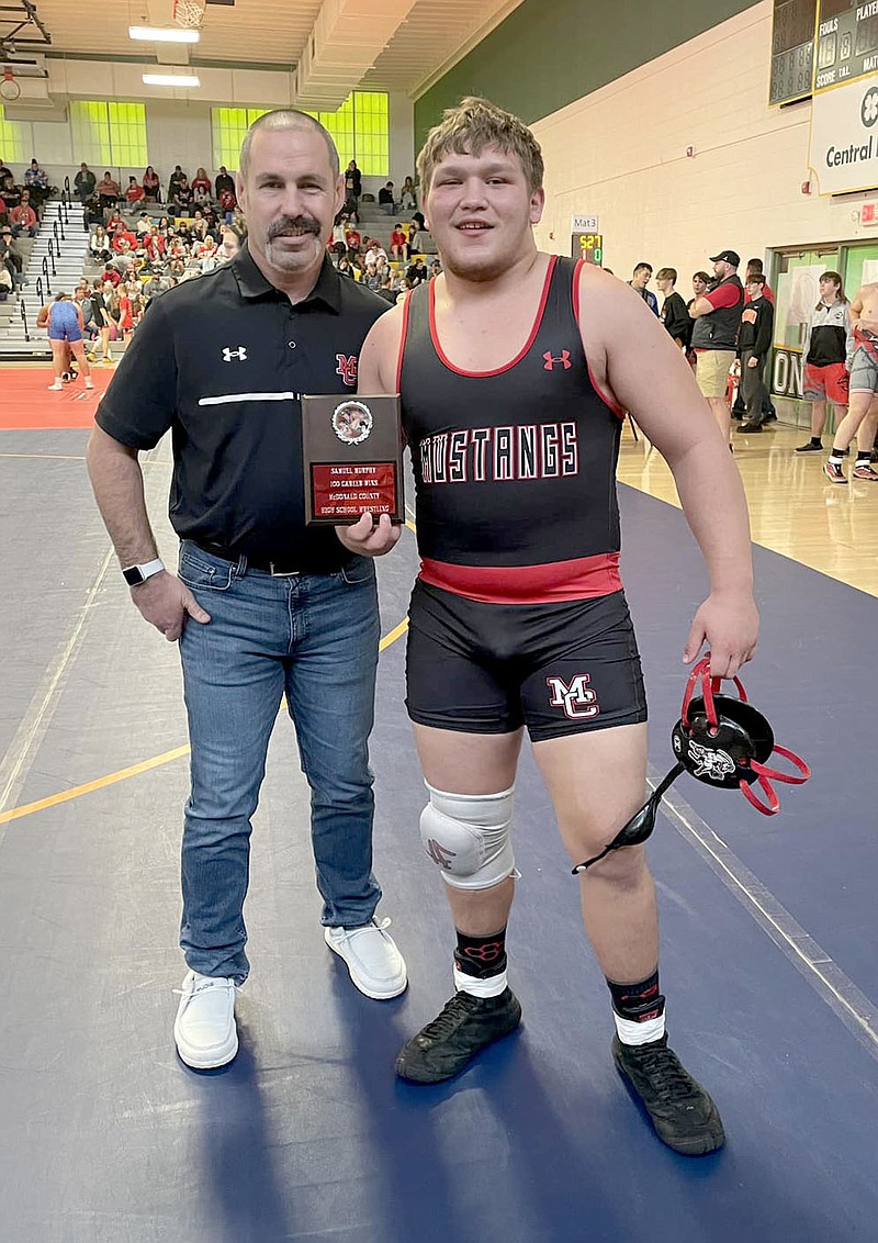 Photo Submitted
McDonald County junior Samuel Murphy, right, is presented with a plaque from MCHS wrestling coach Josh Factor, recognizing career win No. 100 during the Kinloch Classic last weekend in Springfield.