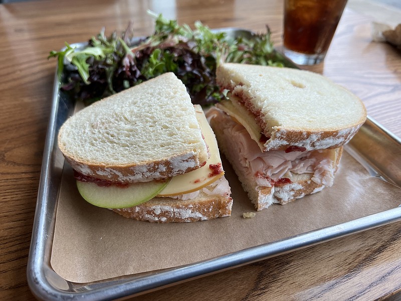 The Turkey Apple Gouda sandwich at Blackberry Market features a generous portion of sliced turkey, thinly sliced Granny Smith apples and Gouda, layered with chutney; we had the kitchen hold the spring mix, in part because sandwiches come with a house salad. (Arkansas Democrat-Gazette/Eric E. Harrison)