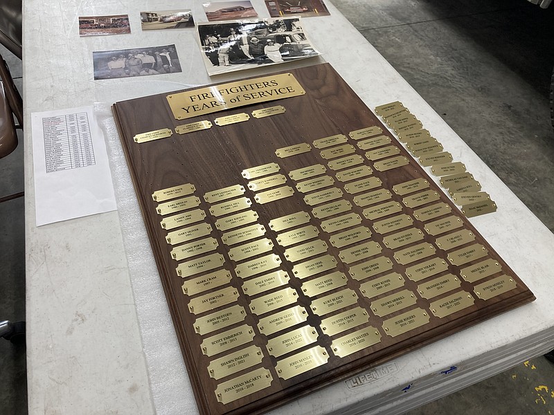 Democrat photo/Garrett Fuller — A plaque containing the names of previous and current California Fire Department firefighters is seen Friday (Dec. 30, 2022,) in the California fire station with photos of the department over the years. Fire Chief Brad Friedmeyer is still finishing up the project, awaiting a new plate for additional names.