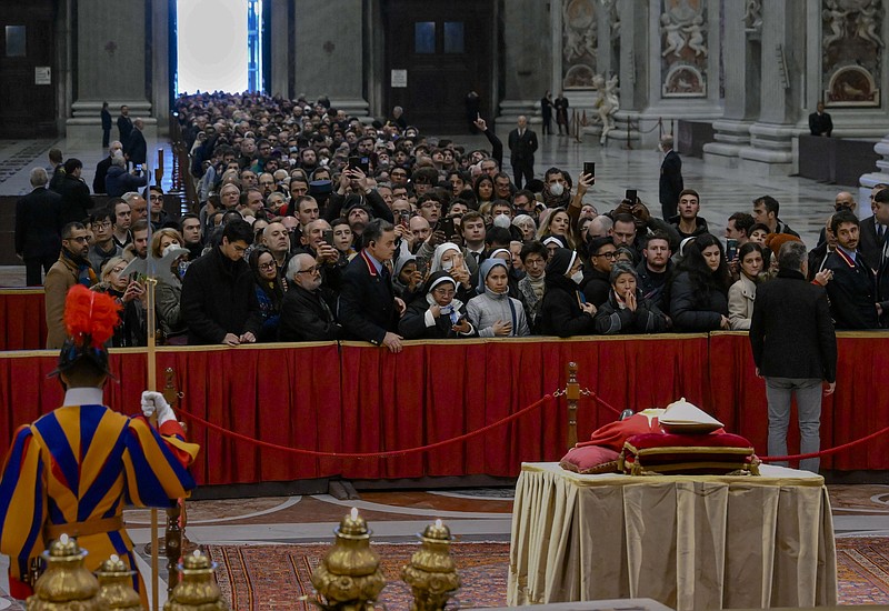 The body of late Pope Emeritus Benedict XVI lies in state as a crowd of visitors pay their respects Monday, Jan. 2, 2023, inside St. Peter's Basilica at the Vatican. Benedict, the German theologian who will be remembered as the first pope in 600 years to resign, died Saturday, Dec. 31, 2022. He was 95. (Vatican Media via AP)