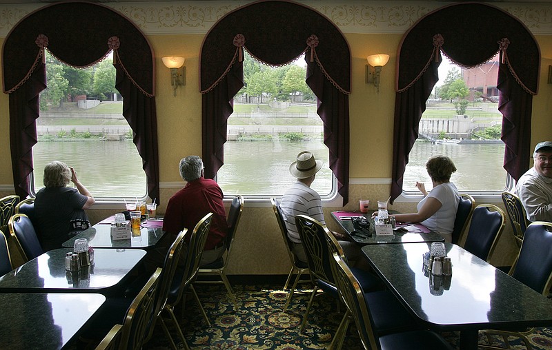 Guests onboard the Arkansas Queen riverboat look out the dining room windows June 3, 2006, while waiting for their luncheon cruise meal. For Remember when 1/9/23. (Democrat-Gazette file photo)