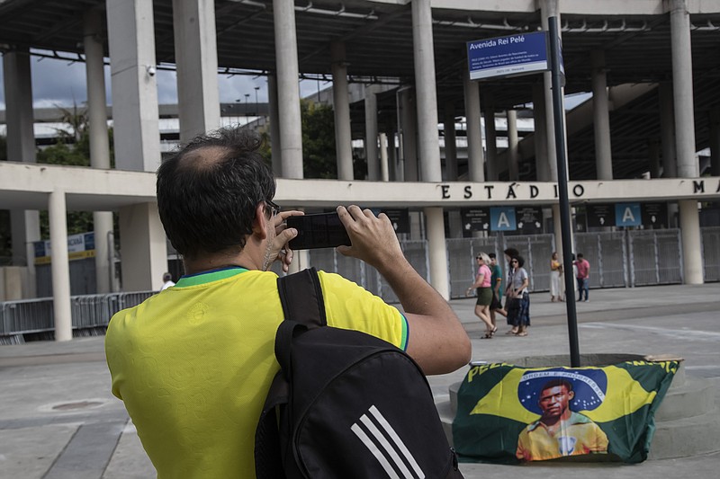 Un hombre fotografía un letrero con el nuevo nombre de la avenida que rodea el Estadio Maracaná en Río de Janeiro, el miércoles 4 de diciembre de 2022. La vía se llama ahora Avenida Rey Pelé (AP Foto/Bruna Prado)