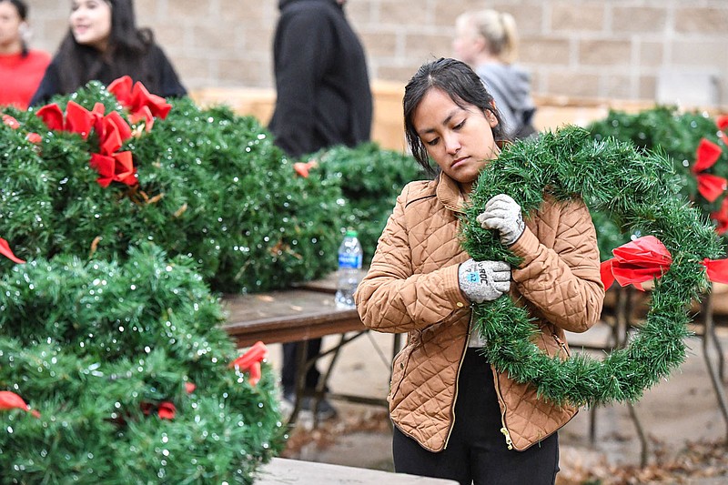 Janely Lopez, a student at Fort Smith Southside High School, gathers and stores wreaths, Thursday, Jan. 5, 2023, at the Fort Smith Convention Center in downtown Fort Smith. Lopez was among dozens of volunteers who helped pick up wreaths from the gravestones at the nearby Fort Smith National Cemetery and store them away for next year in Hall C of the Convention Center. It was the final stage of the annual Christmas Honors event, which will return in early December with the unboxing and placing of wreaths at each of the more than 16,000 gravestones at the cemetery. Visit nwaonline.com/photo for today's photo gallery.
(NWA Democrat-Gazette/Hank Layton)