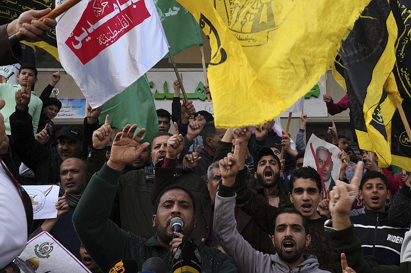 Hamas and Islamic Jihad supporters chant slogans while other holds a placard with a crossed-out photo of Israeli Prime Minister Benjamin Netanyahu during a protest in support of Al-Aqsa Mosque and against the crimes of the occupation in the violation of Al-Aqsa and the holy places, after Friday prayer in front of Al-Hoda mosque in Rafah refugee camp, southern Gaza Strip, Friday, Jan. 6, 2023. (AP Photo/Adel Hana)