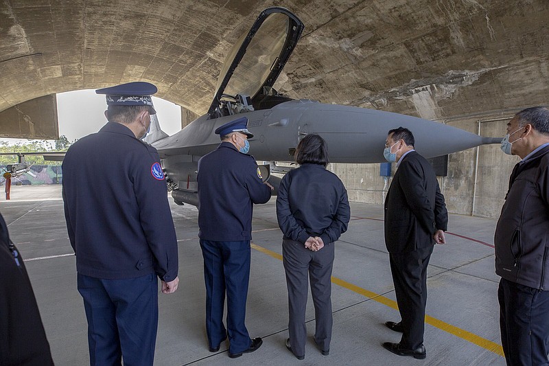 In this photo released by the Taiwan Presidential Office, Taiwan's President Tsai Ing-wen, center, accompanied by officials, looks at the F-16 fighter jet at a military base in Chiayi, southwestern Taiwan, Friday, Jan. 6, 2023. President Tsai visited a military base Friday to observe drills while rival China protested the passage of a U.S. Navy destroyer through the Taiwan Strait, as tensions between the sides showed no sign of abating in the new year.  (Taiwan Presidential Office via AP)