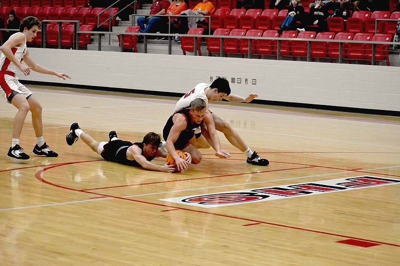 MARK HUMPHREY  ENTERPRISE-LEADER/Gravette and Farmington players chase the ball after a deflection. The wild scramble only ended with Gravette calling time-out to preserve its possession. The Cardinals won 90-50 on Friday. The loss dropped Gravette's conference record to 2-2 among 4A-1 boys basketball teams.