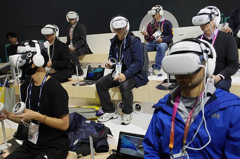 Attendees wear VR headsets while previewing the Caliverse Hyper-Realistic Metaverse experience at the Lotte booth during the CES tech show Friday, Jan. 6, 2023, in Las Vegas. (AP Photo/John Locher)