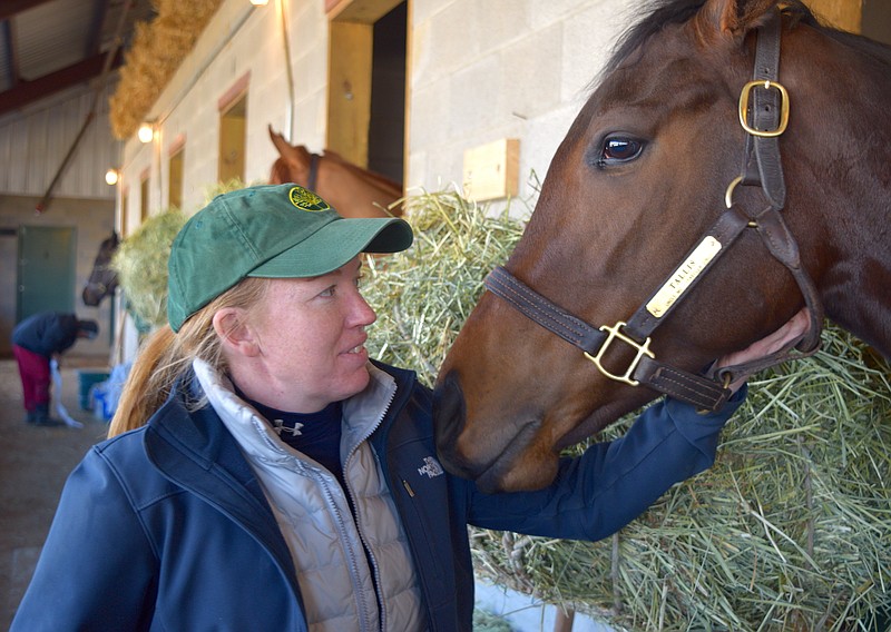Trainer Lindsay Schultz rubs the face of Alex Joon, a 5-year-old gelding that Schultz trains for Ten Strike Racing. - Photo by Donald Cross of The Sentinel-Record