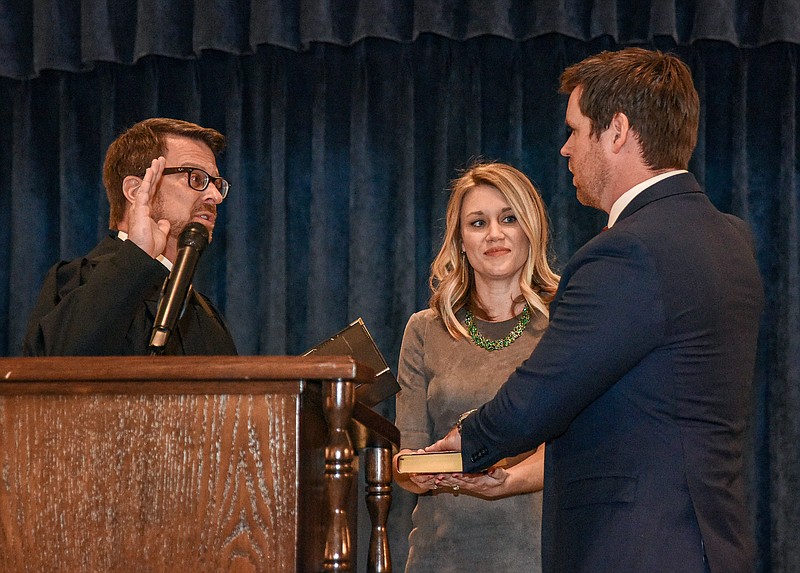 Julie Smith/News Tribune photo: 
Scott Fitzpatrick, at right, repeats the oath of office as state auditor as adminstered by Judge Jack A.L. Goodman of the Court of Appeals Southern District, at left, as Mallory Fitzpatrick holds the bible on which the auditor took his oath.