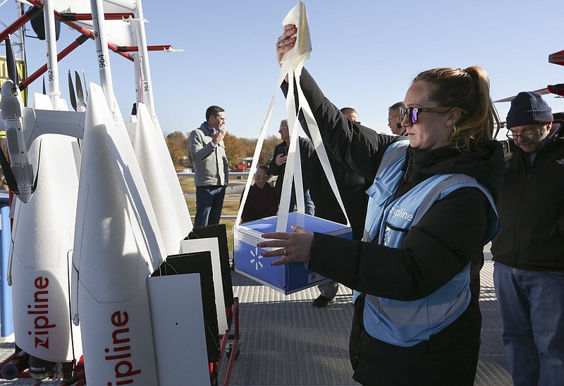 Julianna Martorella, flight operator controller, places a package inside of a drone, Thursday, November 18, 2021 behind the Walmart Neighborhood Market on 240 Slack St. in Pea Ridge. Walmart demonstrated its new drone station in Pea Ridge in a media tour. The device by Zipline takes off from a 25-foot tower behind the Neighborhood Market. Although they have been testing drone delivery in other states, this is their first time using the company Zipline, which uses "propriety technology." Check out nwaonline.com/211119Daily/ for today's photo gallery. 
(NWA Democrat-Gazette/Charlie Kaijo)