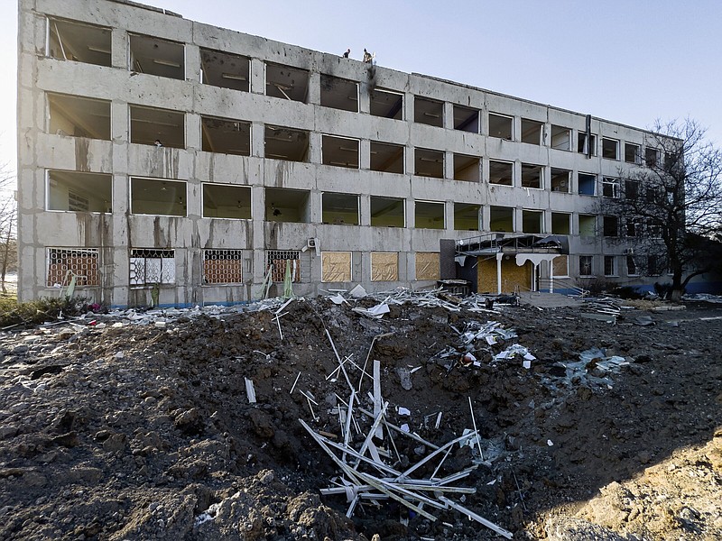 Municipal workers clear the rubble on the roof of College No. 47 which was damaged by a Russian rocket attack in Kramatorsk, Ukraine, Monday, Jan. 9, 2023. (AP Photo/Evgeniy Maloletka)