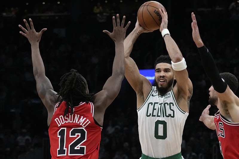 Boston Celtics forward Jayson Tatum (0) looks to pass while pressured by Chicago Bulls guard Ayo Dosunmu (12) during the second half of an NBA basketball game, Monday, Jan. 9, 2023, in Boston. (AP Photo/Charles Krupa)