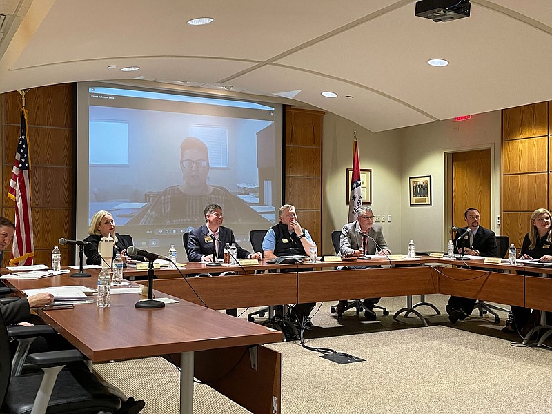 The Northwest Arkansas Community College Board of Trustees and Dennis Rittle, college president, listen to Diana Johnson, senior vice president for learning, who is shown speaking on the screen behind them during the board's meeting Monday, Jan. 9, 2023.